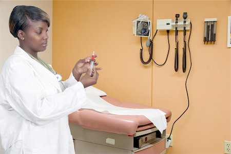 A black African American woman doctor preparing a shot for a patient Stock Photo - Budget Royalty-Free & Subscription, Code: 400-04794340