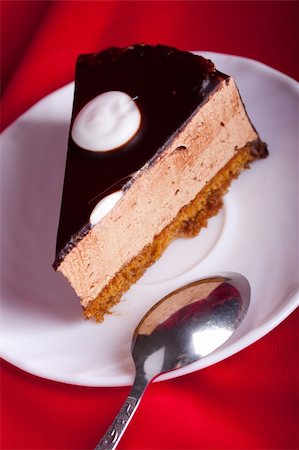 simsearch:400-05173009,k - chocolate cake with spoon on the plate on red silk background. Shallow focus Stock Photo - Budget Royalty-Free & Subscription, Code: 400-04795412