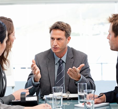 Severe manager talking to his team at a table during a meeting Stock Photo - Budget Royalty-Free & Subscription, Code: 400-04791812