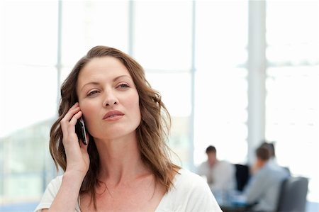 simsearch:400-05746962,k - Attractive businesswoman on the phone while her team is working in the background Stock Photo - Budget Royalty-Free & Subscription, Code: 400-04791823