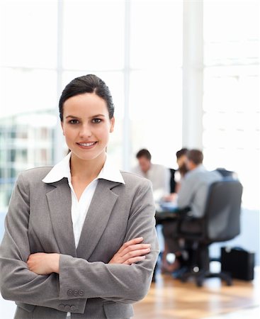 simsearch:400-05746962,k - Cheerful businesswoman standing in front of her team while working in the background Stock Photo - Budget Royalty-Free & Subscription, Code: 400-04791947