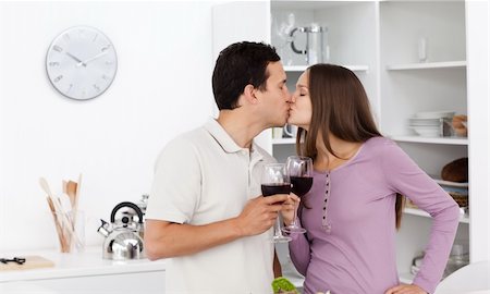 food specialist - Cute couple kissing with glasses of red wine in their hands in the kitchen Photographie de stock - Aubaine LD & Abonnement, Code: 400-04791980