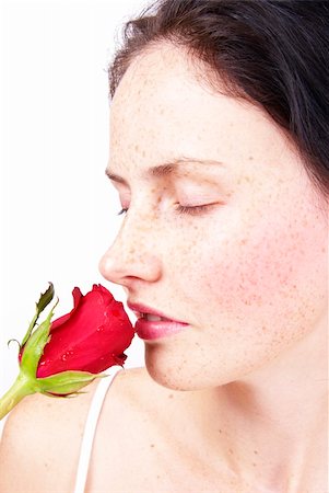Beautiful brunette woman holding a single red rose to her nose to smell Photographie de stock - Aubaine LD & Abonnement, Code: 400-04805746