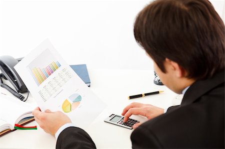 simsearch:400-05748170,k - Business man sitting at office desk and checking financial report Stock Photo - Budget Royalty-Free & Subscription, Code: 400-04803111