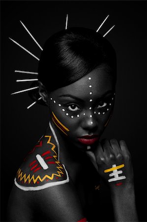 Beautiful exotic African female fashion face with tribal yellow red and white makeup cosmetics and sticks in hair. Stock Photo - Budget Royalty-Free & Subscription, Code: 400-04803759