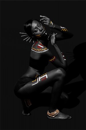 Beautiful exotic African female fashion with tribal yellow red and white makeup cosmetics and sticks in hair, in cultural dance position. Stock Photo - Budget Royalty-Free & Subscription, Code: 400-04803751