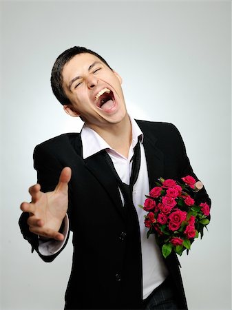 simsearch:400-04739802,k - Expressions. screaming husband holding rose flower and vine bottle prepared for a date. gray background Stock Photo - Budget Royalty-Free & Subscription, Code: 400-04815508