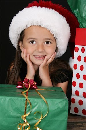 dreaming about eating - Cute brunette girl sitting amongst christmas gifts Stock Photo - Budget Royalty-Free & Subscription, Code: 400-04820209
