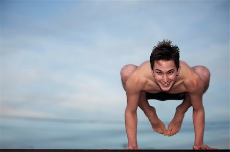 Happy young Caucasian man doing the Bakasana posture Photographie de stock - Aubaine LD & Abonnement, Code: 400-04839456