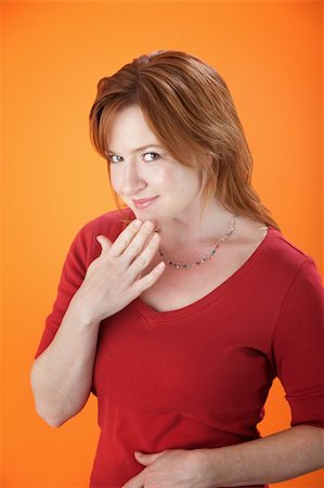 simsearch:400-05388090,k - Slightly embarrassed Caucasian woman on orange background Stock Photo - Budget Royalty-Free & Subscription, Code: 400-04831275