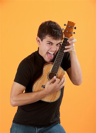 Hispanic teen plays a ukulele with tongue sticking out Stock Photo - Budget Royalty-Free & Subscription, Code: 400-04831314