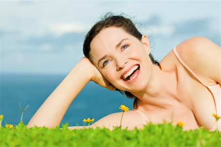 simsearch:400-04416781,k - Beautiful young happy woman laying in green grass with yellow flowers Photographie de stock - Aubaine LD & Abonnement, Code: 400-04840899