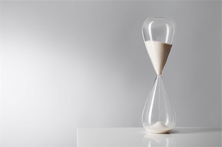 sand clock - Studio photo of a hourglass on reflective table. Photographie de stock - Aubaine LD & Abonnement, Code: 400-04868094