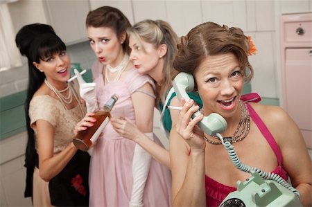Excited woman on phone while friends drink and smoke in the kitchen Stock Photo - Budget Royalty-Free & Subscription, Code: 400-04868706