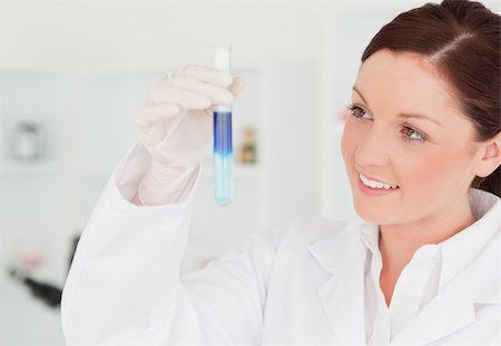 simsearch:400-09011632,k - Smiling red-haired scientist looking at a test tube in a lab Stock Photo - Budget Royalty-Free & Subscription, Code: 400-04879291