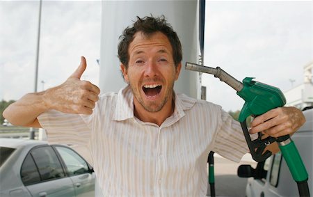 Man happy about decreasing petrol prices Stock Photo - Budget Royalty-Free & Subscription, Code: 400-04871004