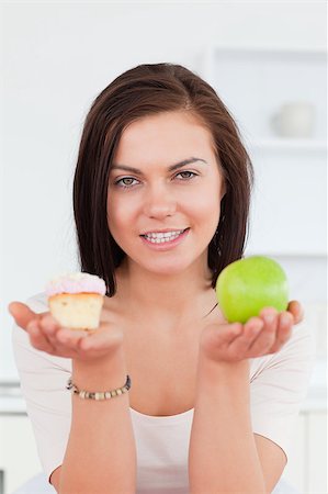 simsearch:400-05106591,k - Portrait of a cute brunette with an apple and a piece of cake looking at the camera Stock Photo - Budget Royalty-Free & Subscription, Code: 400-04884060