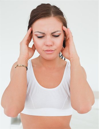Woman having a headache against a white background Stock Photo - Budget Royalty-Free & Subscription, Code: 400-04884418