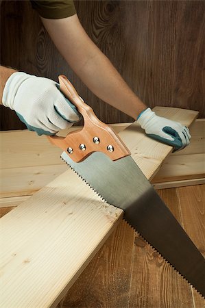 Wood workshop. Carpenter cutting plank with hand saw. Stock Photo - Budget Royalty-Free & Subscription, Code: 400-04887444