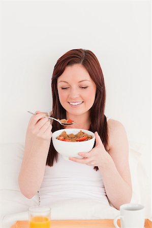 dreaming about eating - Attractive red-haired female having her breakfast while sitting on her bed Stock Photo - Budget Royalty-Free & Subscription, Code: 400-04881635