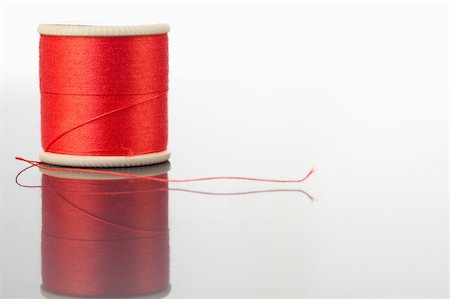 simsearch:400-06079198,k - Red spool of thread on a table against a white background Stock Photo - Budget Royalty-Free & Subscription, Code: 400-04881712