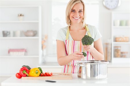simsearch:400-05740111,k - Woman cooking broccoli looks into the camera in the kitchen Stock Photo - Budget Royalty-Free & Subscription, Code: 400-04894323