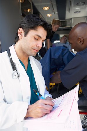 simsearch:400-05343071,k - Doctor taking notes as paramedics unload patient Stock Photo - Budget Royalty-Free & Subscription, Code: 400-04890166