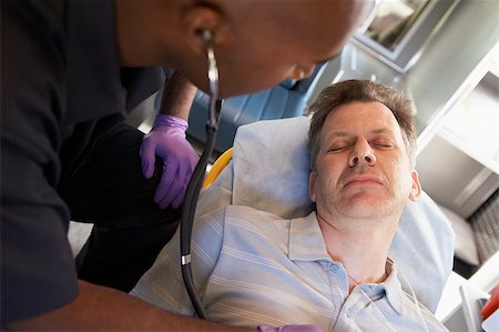 simsearch:400-05343071,k - Paramedic using stethoscope on patient in ambulance Stock Photo - Budget Royalty-Free & Subscription, Code: 400-04890161