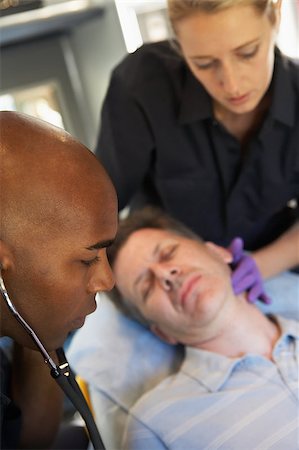 simsearch:400-05343071,k - Paramedic using stethoscope on patient in ambulance Stock Photo - Budget Royalty-Free & Subscription, Code: 400-04890162