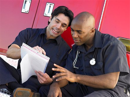 simsearch:400-05343071,k - Two paramedics cheerfully doing paperwork, sitting by their ambu Stock Photo - Budget Royalty-Free & Subscription, Code: 400-04890214
