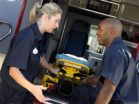 simsearch:400-05343071,k - Two paramedics cheerfully removing empty gurney from ambulance Stock Photo - Budget Royalty-Free & Subscription, Code: 400-04890226