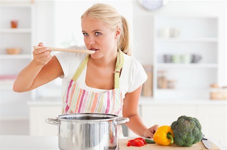 simsearch:400-05740111,k - Woman tasting her meal while wearing a apron Stock Photo - Budget Royalty-Free & Subscription, Code: 400-04904430