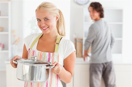 simsearch:400-05740111,k - Portrait of a woman posing while a man is washing the dishes in their kitchen Stock Photo - Budget Royalty-Free & Subscription, Code: 400-04904440