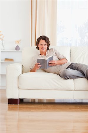 simsearch:400-04418460,k - Portrait of a man holding a book in his living room Stock Photo - Budget Royalty-Free & Subscription, Code: 400-04905657
