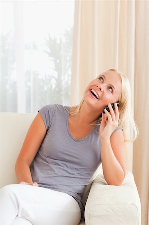 simsearch:400-05717423,k - Portrait of a happy woman speaking on the phone in her living room Stock Photo - Budget Royalty-Free & Subscription, Code: 400-04906063