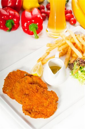 classic breaded Milanese veal cutlets with french fries , vegetables and glass of lager beer on background ,MORE DELICIOUS FOOD ON PORTFOLIO Stock Photo - Budget Royalty-Free & Subscription, Code: 400-04908241