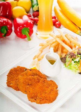 classic breaded Milanese veal cutlets with french fries , vegetables and glass of lager beer on background ,MORE DELICIOUS FOOD ON PORTFOLIO Stock Photo - Budget Royalty-Free & Subscription, Code: 400-04916400