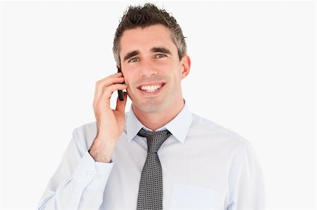simsearch:400-05145011,k - Smiling man making a phone call against a white background Stock Photo - Budget Royalty-Free & Subscription, Code: 400-04918098