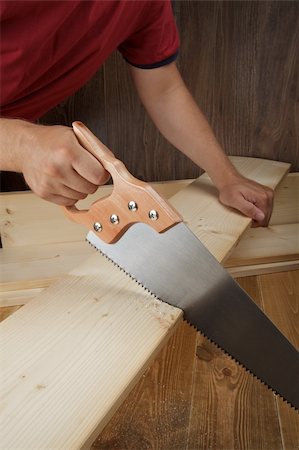 Wood workshop. Carpenter cutting plank with hand saw. Stock Photo - Budget Royalty-Free & Subscription, Code: 400-04911094