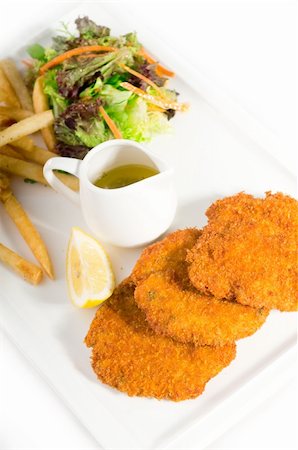classic breaded Milanese veal cutlets with french fries and vegetables on background ,MORE DELICIOUS FOOD ON PORTFOLIO Stock Photo - Budget Royalty-Free & Subscription, Code: 400-04911122