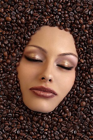 close up of a girl's face immersed in coffee beans keeping her eyes closed Stock Photo - Budget Royalty-Free & Subscription, Code: 400-04925555
