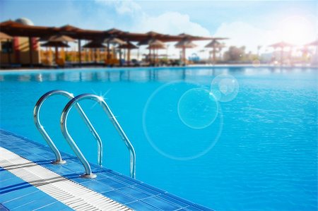 resort pool view - Photo of swimming pool with stair lit by sunlight Stock Photo - Budget Royalty-Free & Subscription, Code: 400-04922714