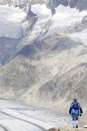 simsearch:400-04269017,k - Lone man climbing a mountain covered with patches of snow. Signs of global warming. Photographie de stock - Aubaine LD & Abonnement, Code: 400-04937391
