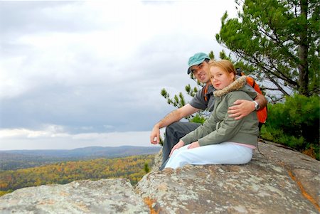 person sitting cliff edge - A parent and a child sitting on a cliff edge enjoying scenic view Stock Photo - Budget Royalty-Free & Subscription, Code: 400-04939957