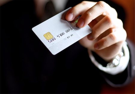 simsearch:400-04434336,k - Business man presenting his credit card. Shallow DOF, focus on chip o card. Concept: Shopping and spending. Stock Photo - Budget Royalty-Free & Subscription, Code: 400-04933222