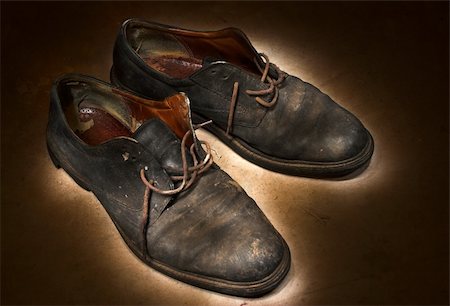 Pair of old, worn out worker's shoes left on a dirty floor after work; photographed in the darkness. Stock Photo - Budget Royalty-Free & Subscription, Code: 400-04949102
