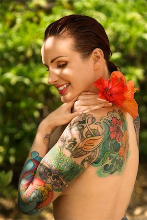 simsearch:400-04450827,k - Attractive smiling Caucasian tattooed woman with Hibiscus flower over her shoulder in Maui, Hawaii, USA. Stock Photo - Budget Royalty-Free & Subscription, Code: 400-04955679