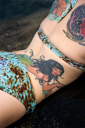 simsearch:400-04450827,k - Sexy tattooed Caucasian woman in bikini lying in tidal pool in Maui, Hawaii, USA. Stock Photo - Budget Royalty-Free & Subscription, Code: 400-04955745