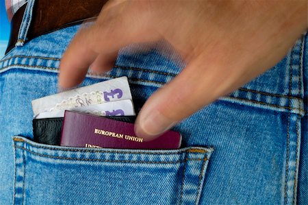 A wallet with £20 notes and a passport poke out of the rear pocket of a traveller's jeans. Motion blur on a pickpocket's hand, about to take them. Stock Photo - Budget Royalty-Free & Subscription, Code: 400-04978571