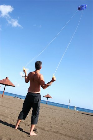 pictures of boy fly kites in the sky - Man flying a kite on the beach Stock Photo - Budget Royalty-Free & Subscription, Code: 400-04979533